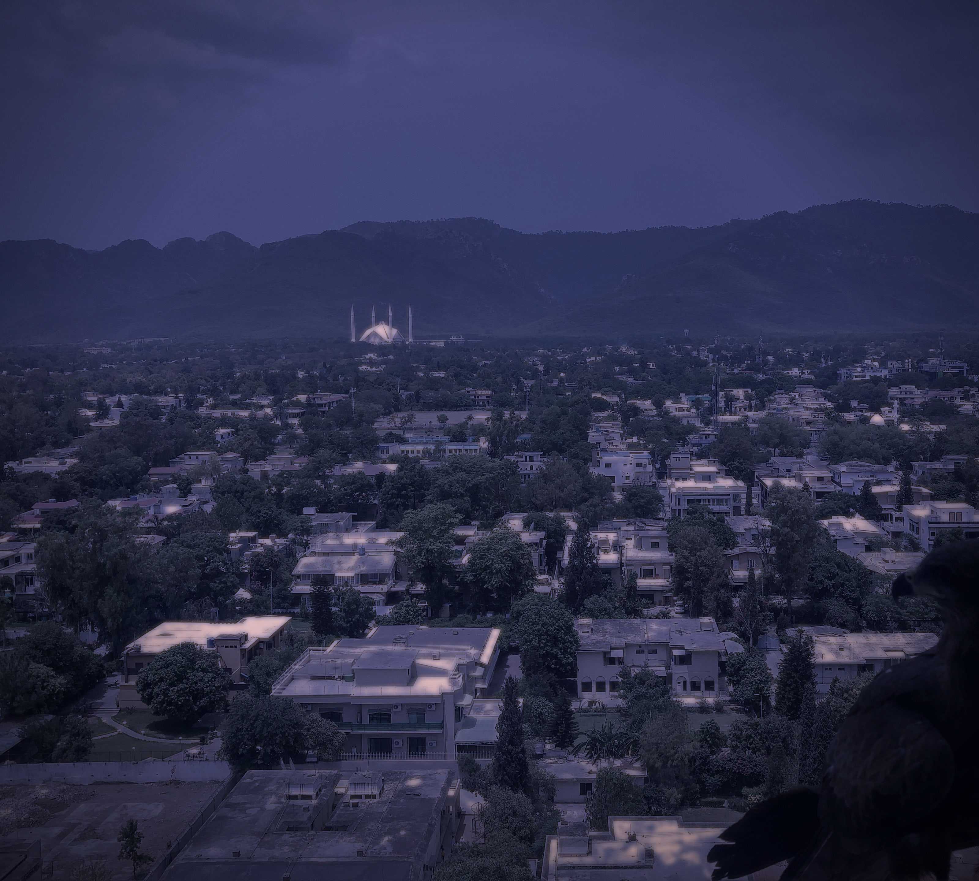 The same view over Islamabad at night, with the city lights on below the Margalla Hills