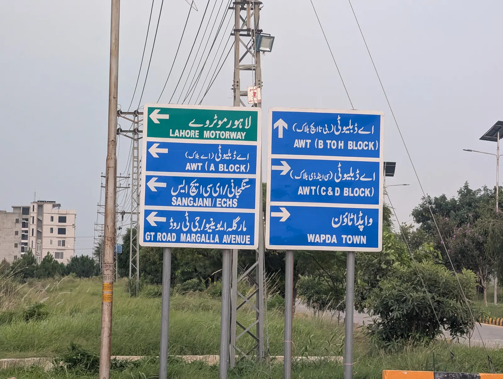 Directional signboard at the AWT junction — Lahore Motorway, blocks A–D, Sangjani, Wapda Town