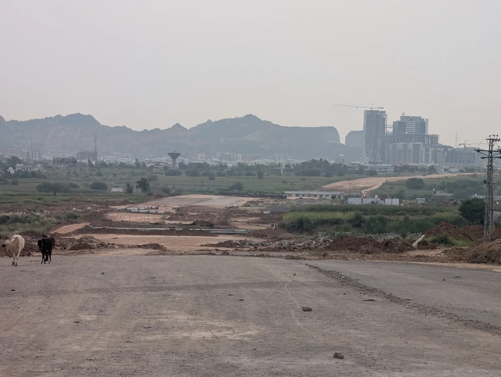 Margalla Road under construction on the edge of AWT D-18, with the Margalla Hills behind